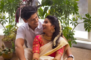 Geleneksel kıyafetli mutlu çift Onam 'da evde birlikte oturuyorlar.