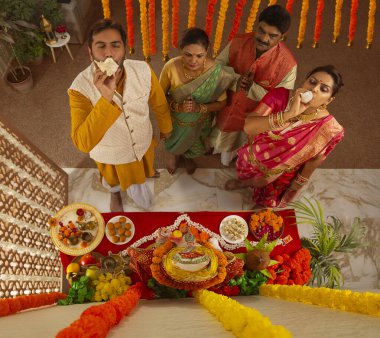 Ganesh Chaturthi vesilesiyle Tanrı Ganesha 'ya dua eden Maharashtrian ailesinin yukarıdan görünüşü