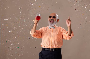 Kıdemli adam bir kadeh kırmızı şarapla kutlama yapıyor.