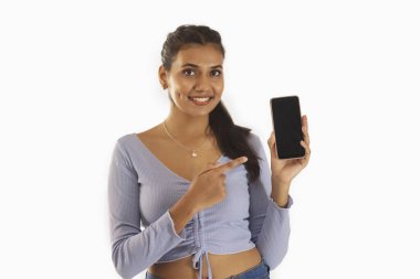 Beyaz arka planda akıllı telefonu tutan kadını işaret ediyor.