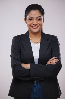 Mutlu bir iş kadınının portresi. Elleri çaprazlanmış kameraya bakıyor.