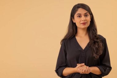 El ele tutuşup kameraya bakan genç bir kadının portresi.