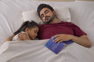Bir baba ve kızı birlikte uyuyorlar.
