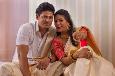 Geleneksel kıyafetli mutlu çift kamerayı Onam 'a çeviriyor.