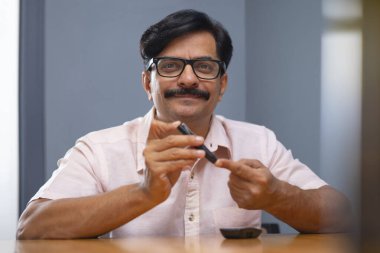 Evde kan şekerini ölçen bir adam var.