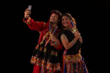 Navratri kutlamaları sırasında birlikte selfie çeken Gujarati çifti portresi.