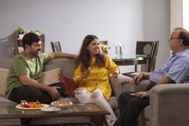 Mutlu Hintli aile evde oturup Raksha Bandhan hakkında konuşuyor.