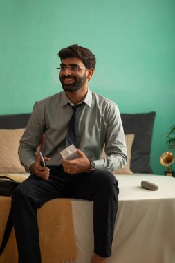 Young ofis için hazırlanırken yatakta oturuyor.