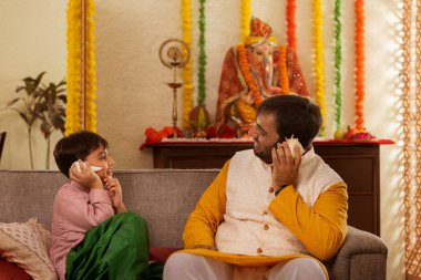 Baba ve oğul evde birlikte otururken deniz kabuğu dinliyorlar.