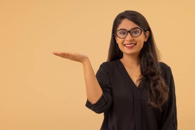 Elini kaldırıp kameraya bakan genç bir kadının portresi.