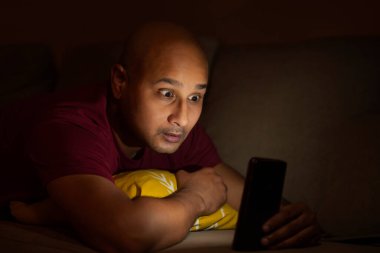 Kel bir adam karanlıkta seyyar bir şey seyrediyor. Yüzünde hayret verici bir ifade var..