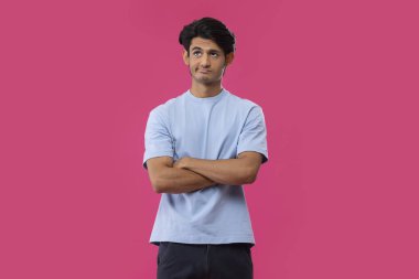 Mavi arka planda duran üzgün bir gencin portresi