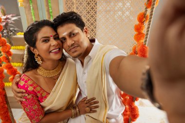 Onam 'da evde salıncakta sallanırken selfie çeken çift.