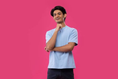 Gülümseyen bir gencin portresi pembe arka planda dururken el kol hareketi yapıyor.