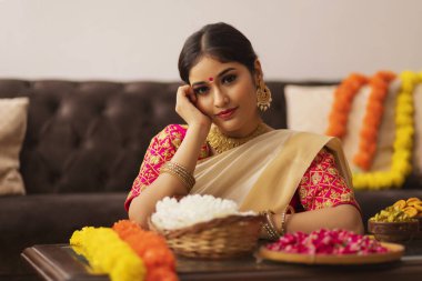 Onam 'ı kutlamak için beyaz sari çiçekli Güney Hintli kadın.