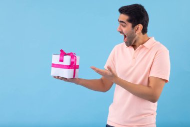 Elinde hediye tutan mutlu genç adamın portresi.