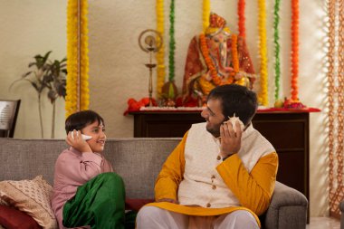 Baba ve oğul evde birlikte otururken deniz kabuğu dinliyorlar.