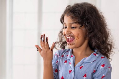 A girl having fun while eating chocolate with hand clipart