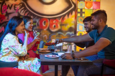 Arkadaşlar restoranda yemek yiyor.