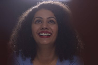 Yetişkin bir kadın sinemada komedi filmi izlerken eğleniyor.