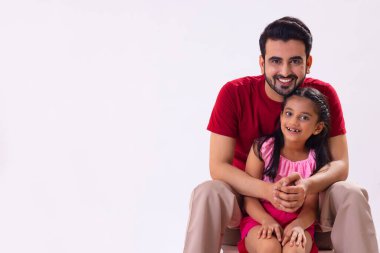 KAMERA 'ya bakan ve oturan mutlu bir baba ve kız.