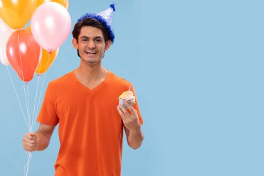 Doğum günü şapkalı, balonlu ve pastalı neşeli bir çocuğun portresi.