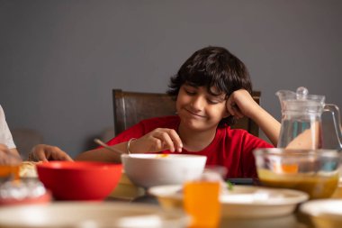 Portrait of boy having lunch at home clipart