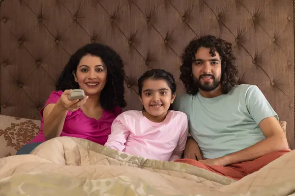 stock image Parent with their daughter together watching television in bedroom