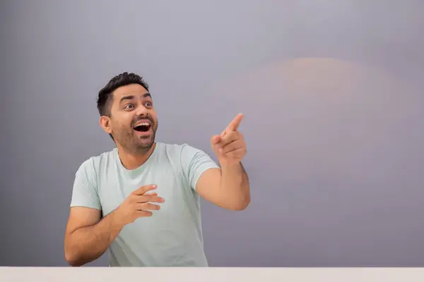 stock image Portrait of a cheerful young man pointing elsewhere