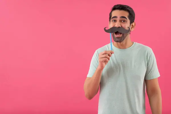 stock image Portrait of  funny young man holding fake mustache and looking at camera