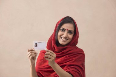 Portrait of a woman standing with her aadhar card. clipart