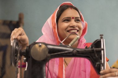 Dikiş makinesiyle sırıtan bir kadın..