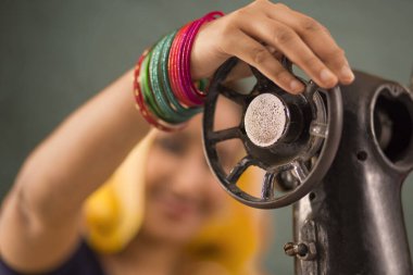 Makineyle dikiş diken bir kadın..