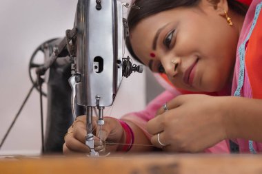 Dikiş makinesinde çalışan bir kadın..