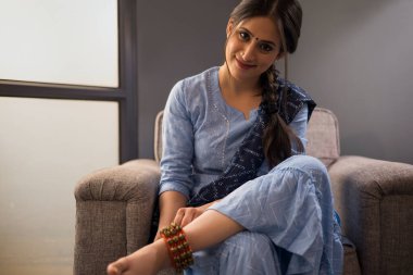 Bir dansçı ghunghroo 'sunu bağlıyor..