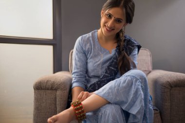 Bir dansçı ghunghroo 'sunu bağlıyor..