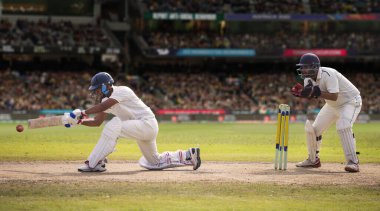 Kriket vurucusu sahadaki bir maçta atış yapıyor.