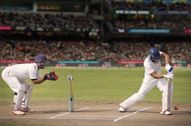 Kriket vurucusu sahadaki bir maçta atış yapıyor.