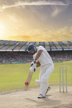 Kriket vurucusu sahadaki bir maçta atış yapıyor.
