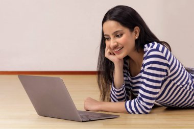 A HAPPY TEENAGER RESTING AND WATCHING LAPTOP clipart