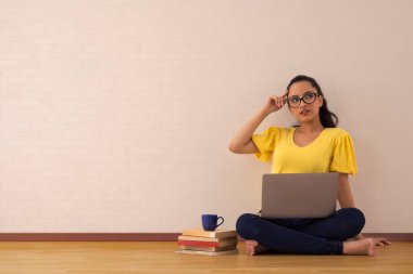 Dizüstü bilgisayarıyla uğraşan genç bir kadın..