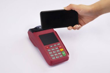 Geçiş makinesi ve cep telefonu tutan bir el..