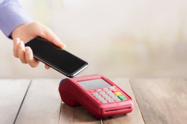 Geçiş makinesi ve cep telefonu tutan bir el..