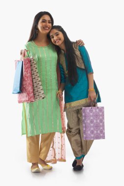 Woman posing with her daughter with shopping bags clipart