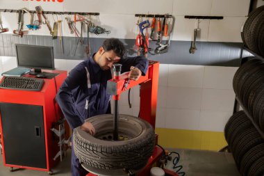 Teknisyen lastik tamircisi üzerinde çalışıyor.