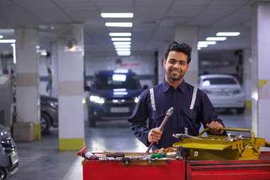 Portrait of happy mechanic in auto repair shop clipart