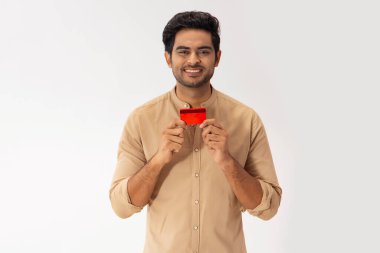 CAMERA 'ya bakan mutlu bir genç adam, kredi kartını elinde tutuyor.