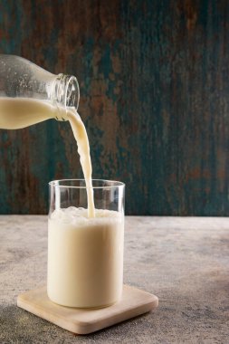 Süt şişeden bir bardağa dökülüyor.