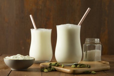 Tereyağı sütü bardakta Kakule ile ahşap masada