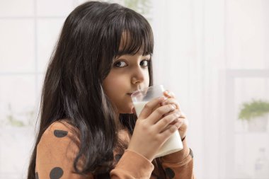 KAMERA 'ya bakan ve süt içen genç bir kız.